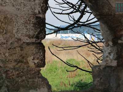 Attraverso una fessura � possibile scorgere in lontananza il moderno edificio di Bariblu...